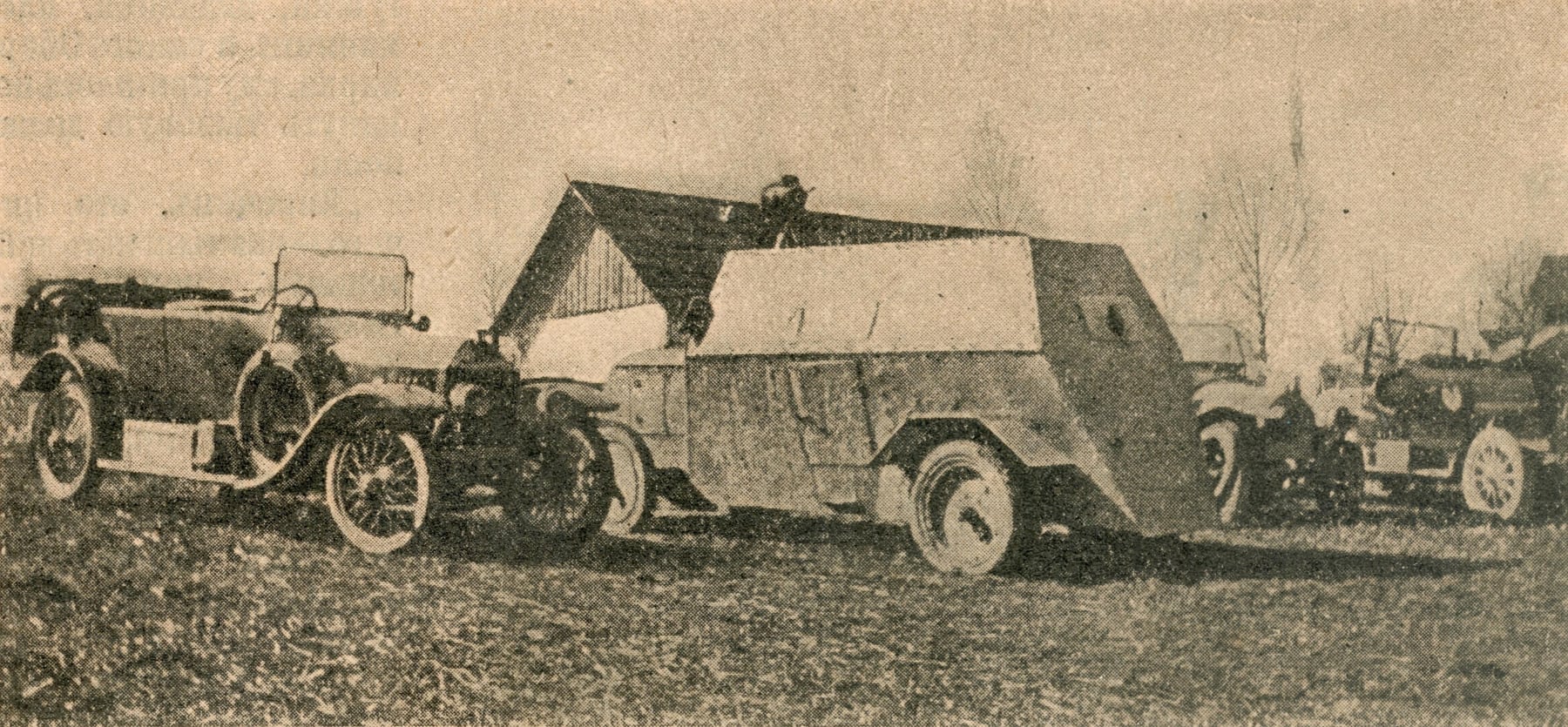A Russo-Balt armoured car of 1916 alongside an open car, archive photograph
