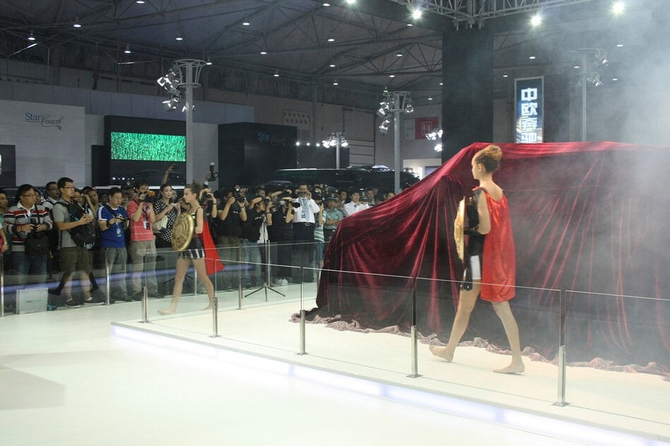 Model beside the red-draped DARTZ Prombron’ before its reveal