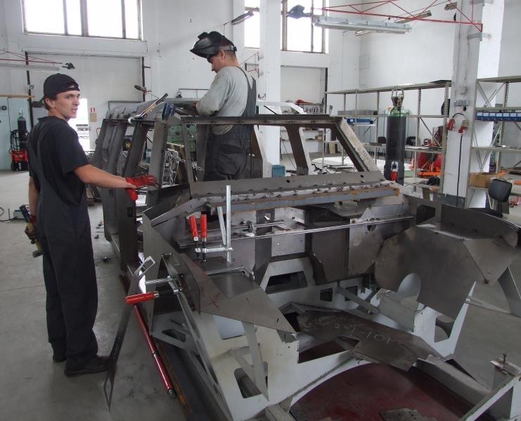 Craftsmen welding a steel armour shell inside the DARTZ workshop