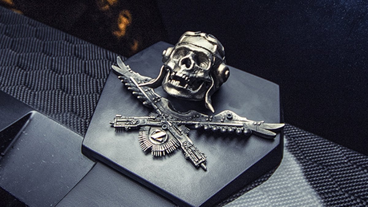 Silver DARTZ skull-and-wings mascot on carbon fibre