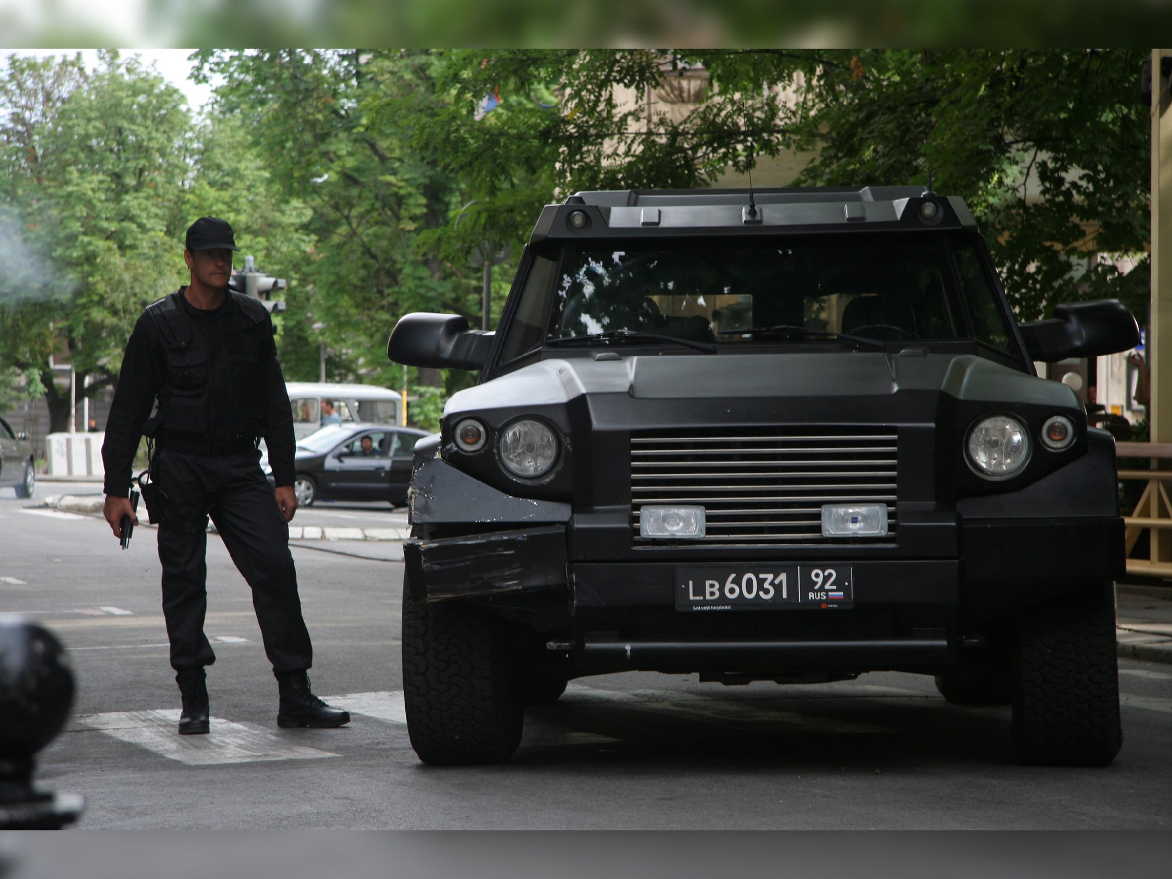 Black DARTZ Prombron’, head-on, with an armed actor on a film set