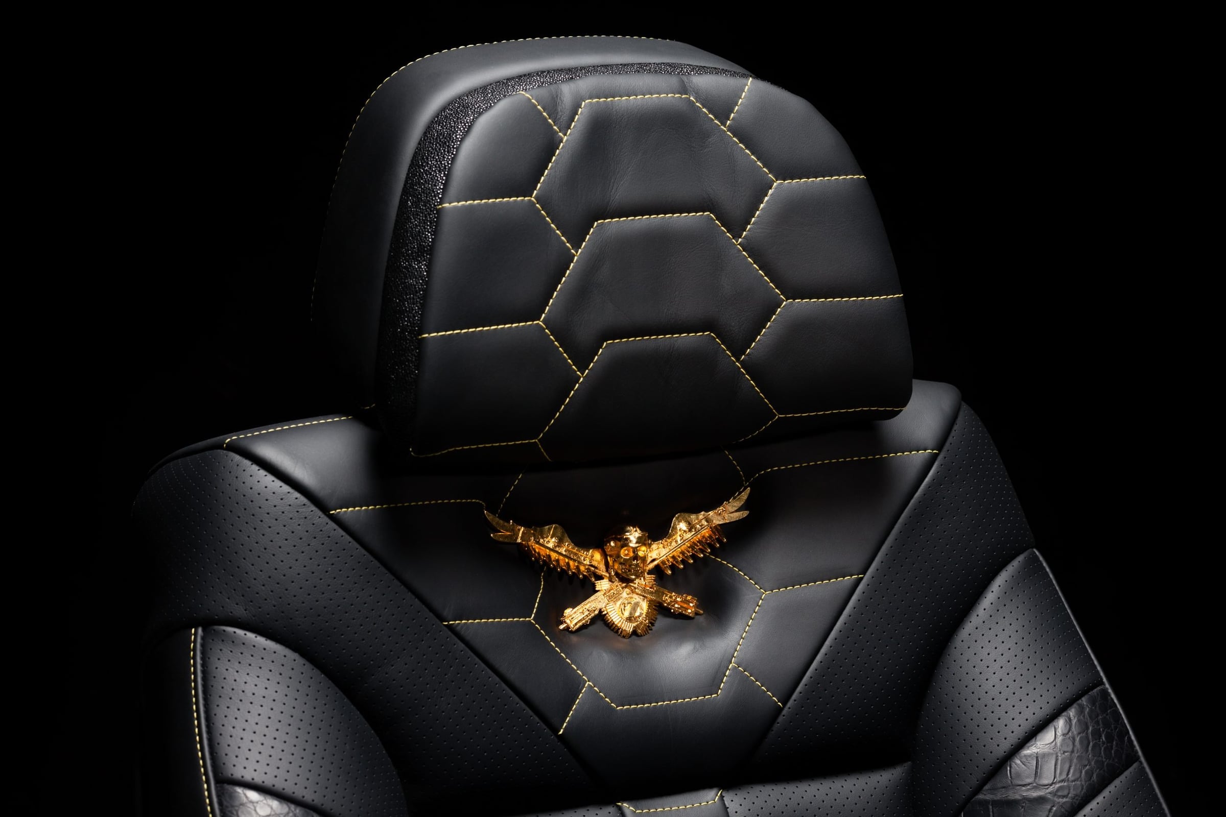 Hexagon-quilted black leather DARTZ seat with a gold eagle crest on the headrest