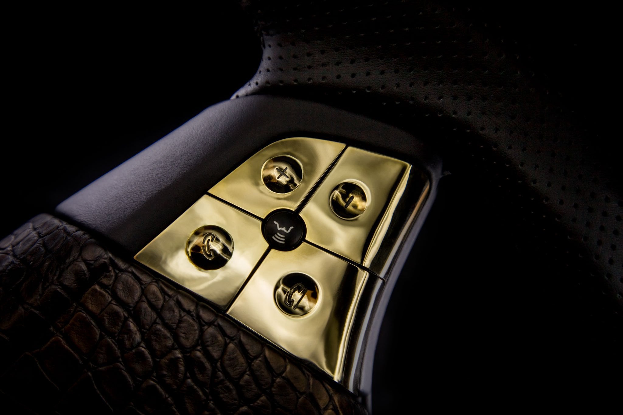Close-up of gold DARTZ steering-wheel controls on crocodile leather