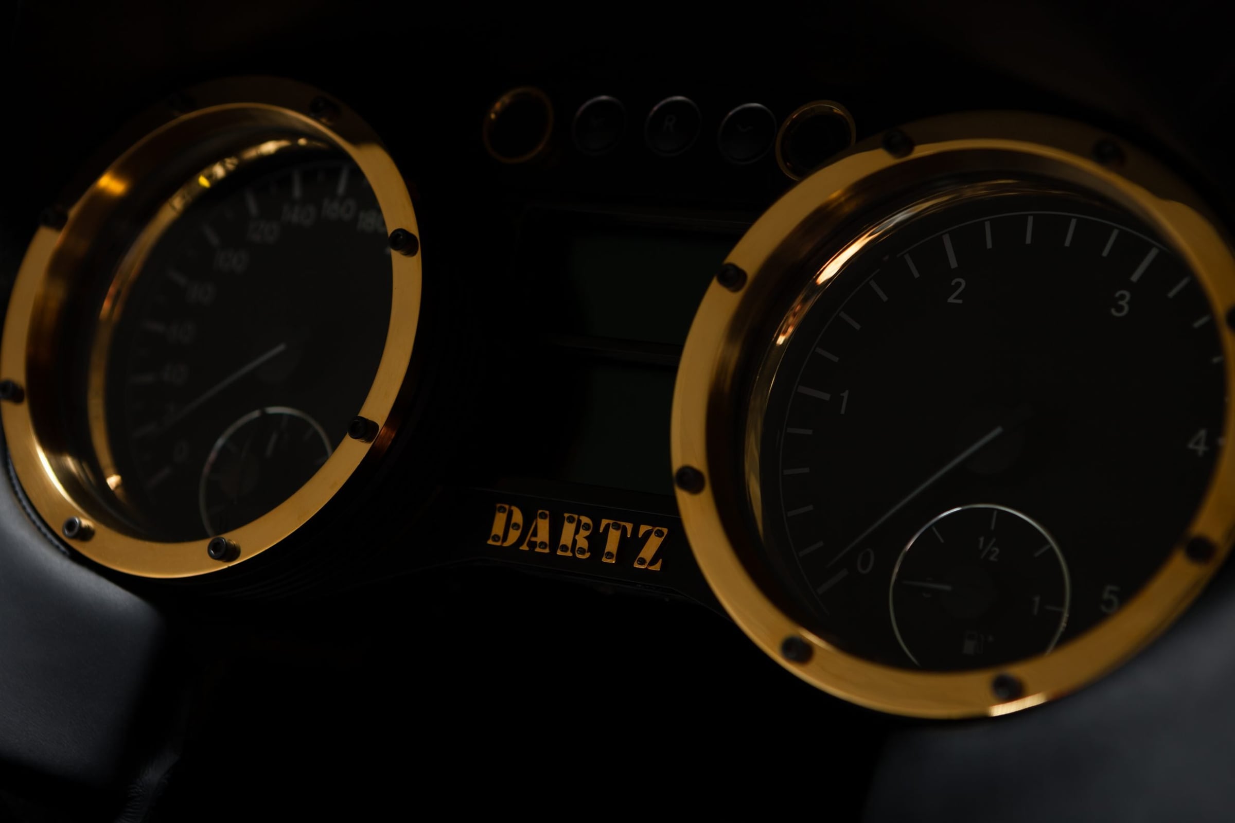 Gold-ringed DARTZ instrument dials lit in the dark