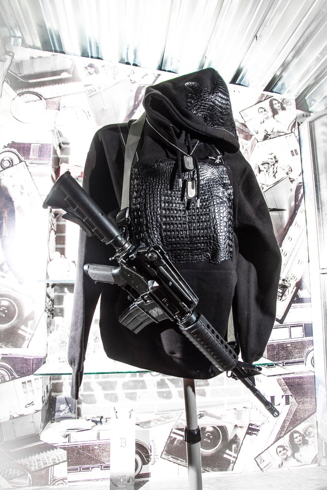 Bulletproof black jacket from the Department of Opulence, displayed with a rifle