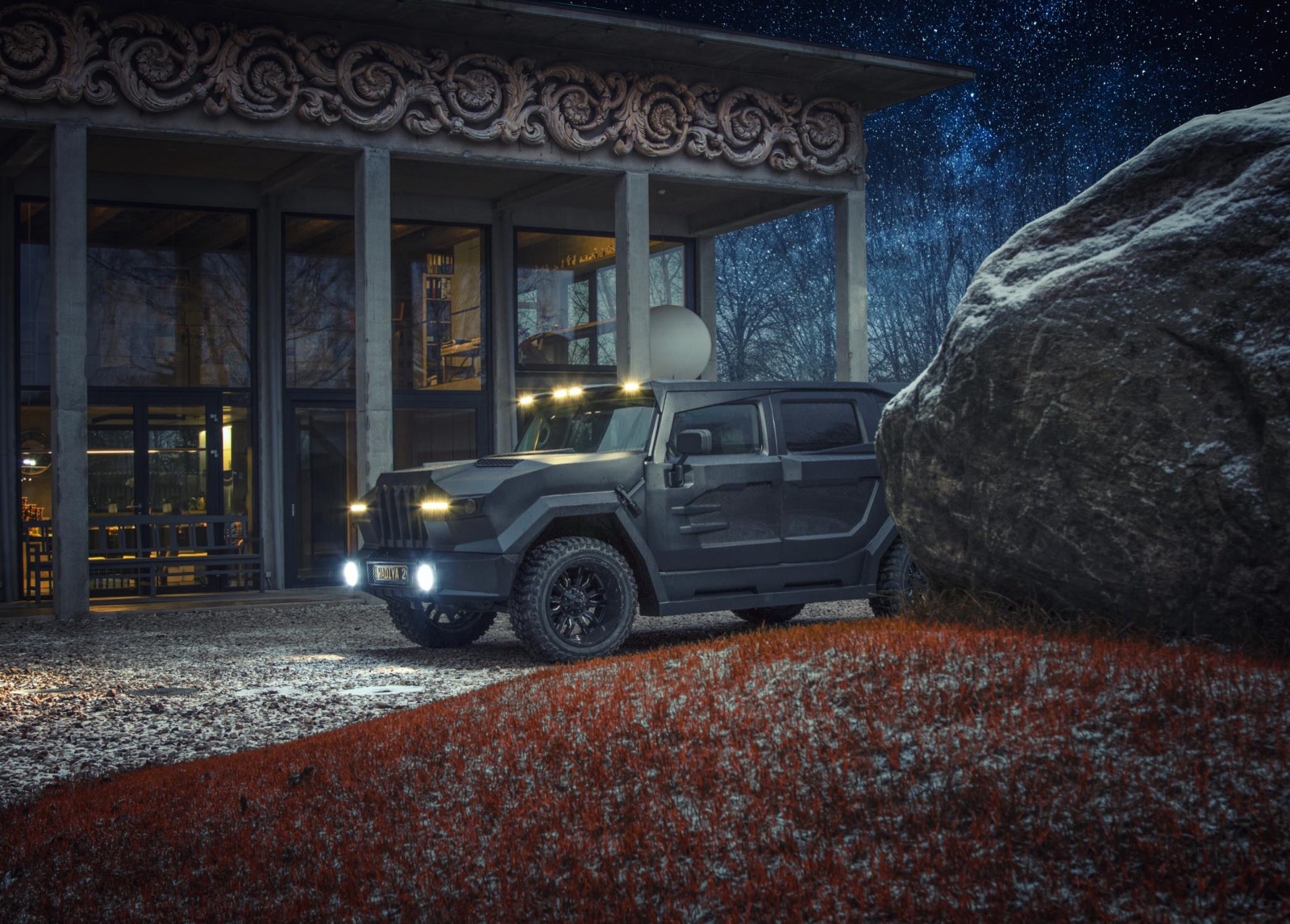 A DARTZ Prombron’ Black Stallion at night outside the DARTZ hall, beside a granite boulder on red heather