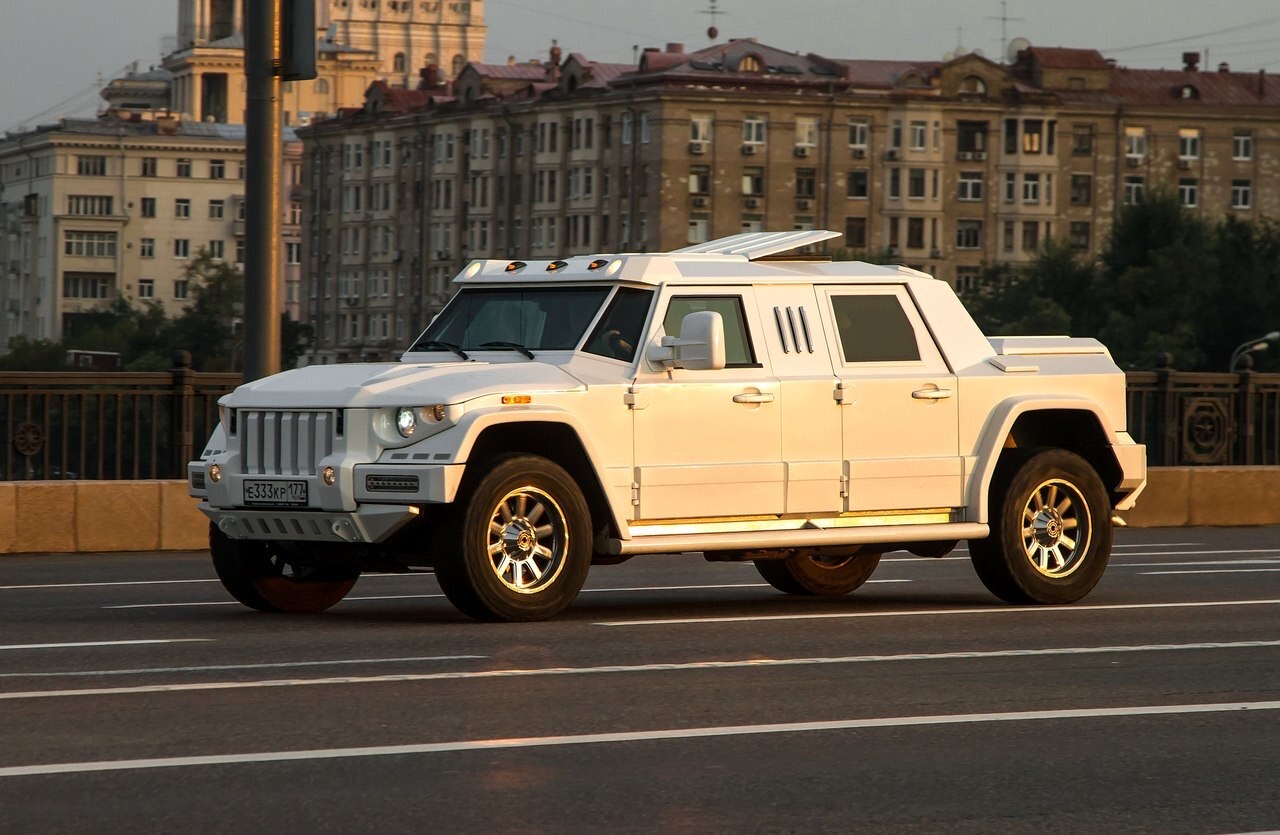 The DARTZ Prombron’ White Horse in white, driving along a city embankment at sunset