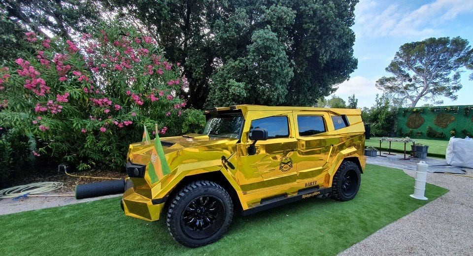 Gold DARTZ Prombron’ Aladeen Edition on a villa lawn with Wadiyan flags